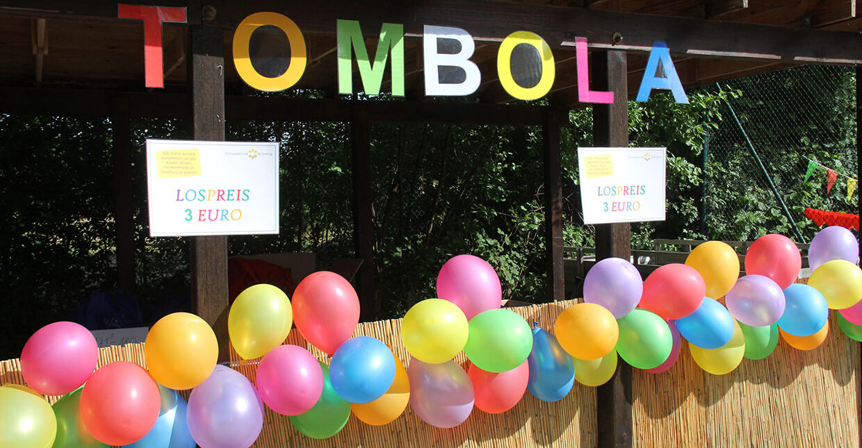 Ein Stand mit der Aufschrift Tombola und vielen bunten Ballons.