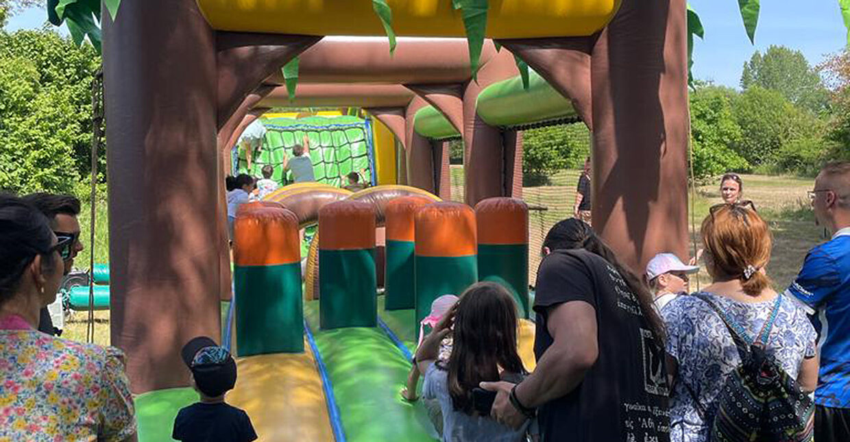 Eine große Hüpfburg mit mehreren, vergnügten Kindern.